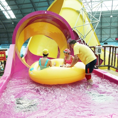 家族相互水演劇のための地面のプール水スライドの上の子供の waterslide